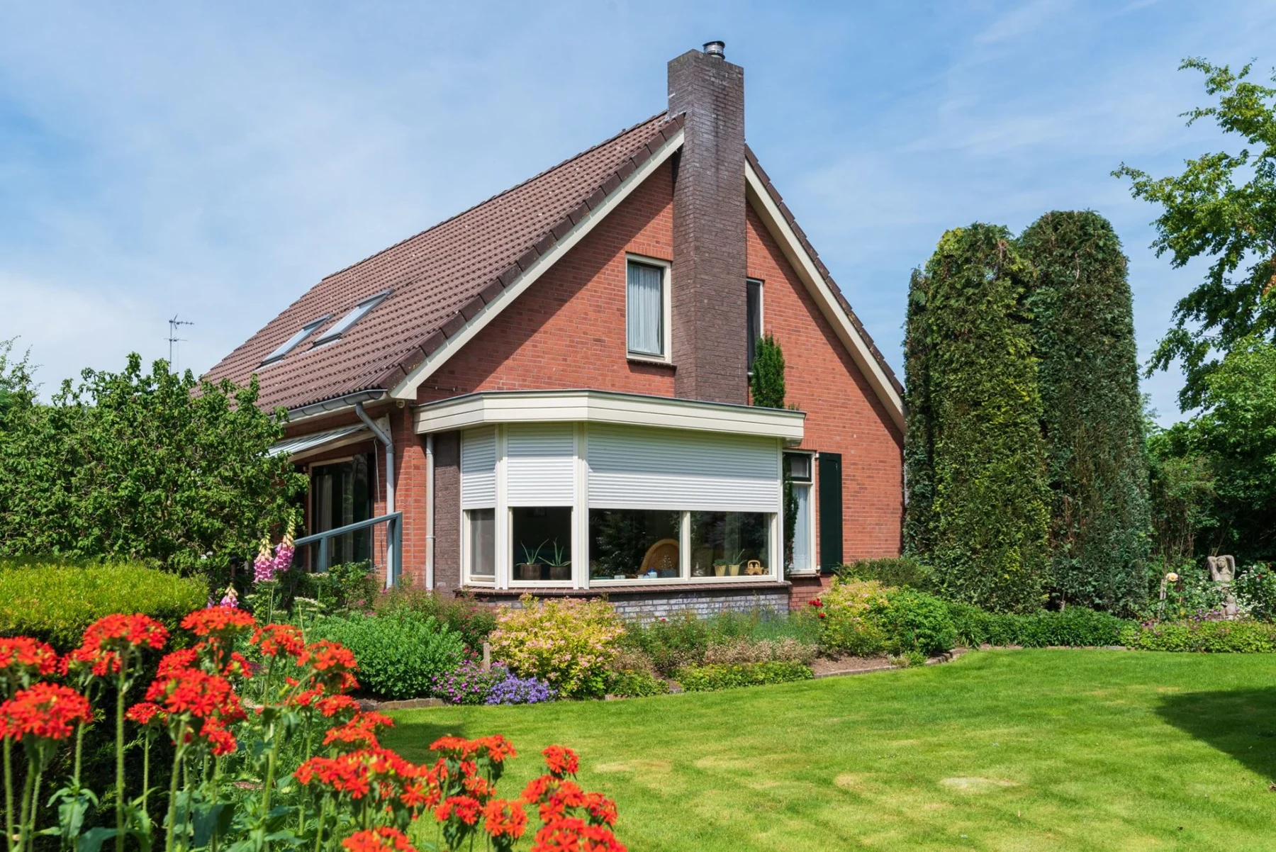 De bakstenen woning aan de Schimmelruiterweg, met een groene tuin